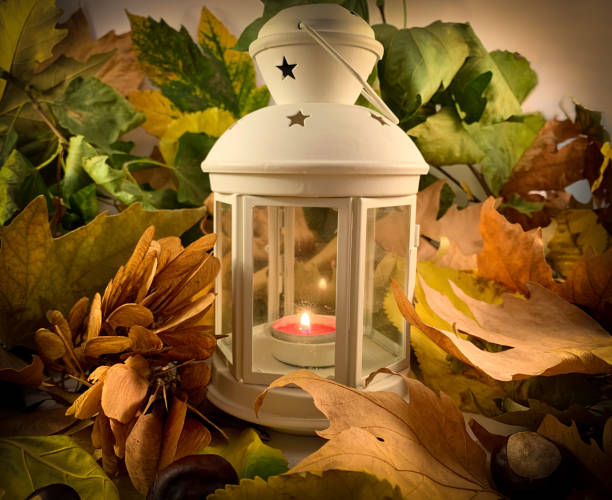 istock Beautiful autumn concept. White lantern with lighted candle surrounded by dry leaves 1280401016