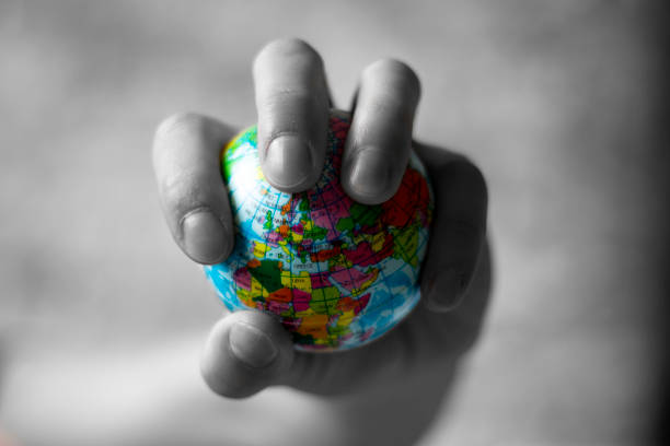 istock Hand squeezing globe, globe in the hand, globe toy, globe in one hand 1280402716