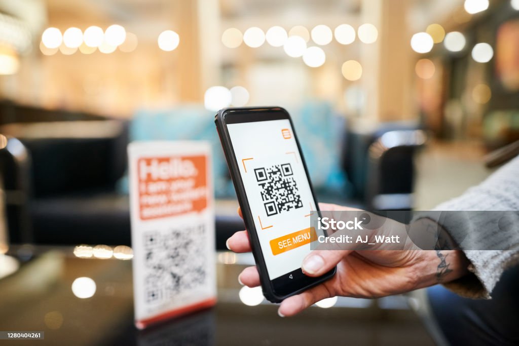 Cashless digital wallet payment Close-up of hand of a woman scanning the qr code with her phone to make a cashless payment in a cafe QR Code Stock Photo