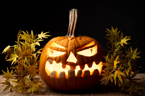 istock glowing pumpkin with autumn leaves 1280406792