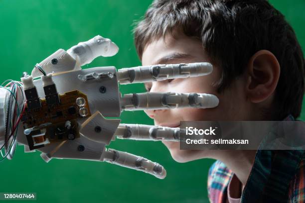Elementary Schoolboy Touching Robotic Hand Stock Photo - Download Image Now - Child, Artificial Intelligence, Green Background
