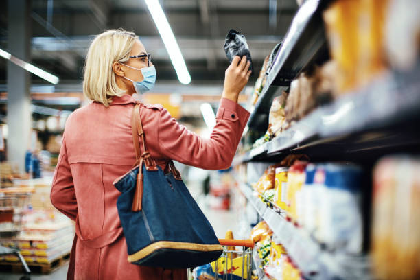 mujer eligiendo comida en el supermercado. - supermarket women packaging blond hair fotografías e imágenes de stock