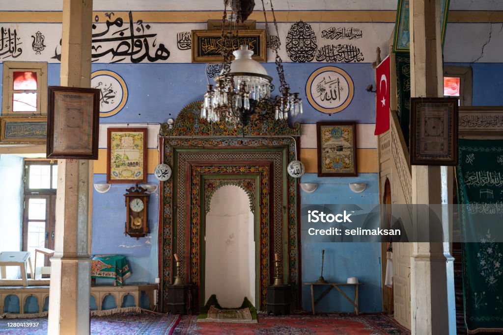 Wooden Ornaments Of Altar In Antique Mosque, Sarihacilar, Akseki, Antalya, Turkey. Altar in antique mosque of Sarihacilar village near Akseki, Antalya, Turkey. The altar has wooden ornaments in Ottoman style. Arabic text on wall read Mohammed and Allah. No people are seen in frame. Shot with a full frame mirrorless camera. Muhammad - Prophet Stock Photo