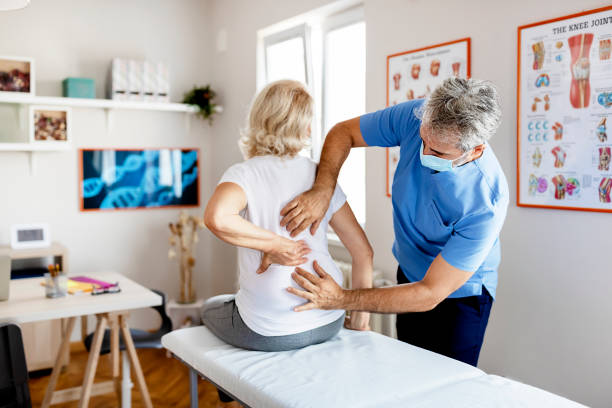 Rehabilitation is just the first step Modern Rehabilitation Physiotherapy Worker With Senior Client in Clinic. Pain Relief Concept. Physiotherapy, Injury Rehabilitation chiropractor treatment stock pictures, royalty-free photos & images