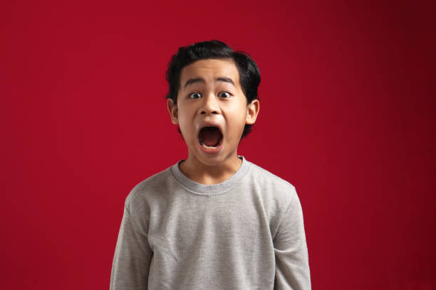istock Asian boy looking at camera with open mouth and big eyes, shocked surprised wow stunned expression to see something amazing 1280418462