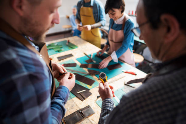 istock Close-up of a senior craftsman teaching a young man about work tool at the workshop class 1280422430