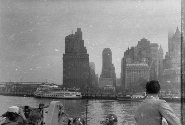 Chrysler building in the New York skyline during the 1950's New York City in the 1950's. New York City comprises 5 boroughs sitting where the Hudson River meets the Atlantic Ocean. At its core is Manhattan, a densely populated borough that’s among the world’s major commercial, financial and cultural centers. Its iconic sites include skyscrapers such as the Empire State Building and sprawling Central Park. Broadway theater is staged in neon-lit Times Square. twin towers manhattan stock pictures, royalty-free photos & images