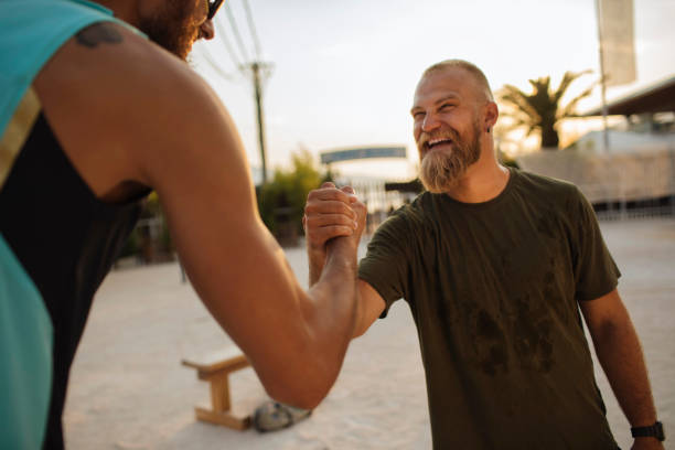 Two fit men shaking hands after working out in an outdoor gym