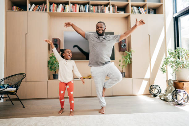 istock Dad dancing with daughter in the living room during lockdown 1280428659