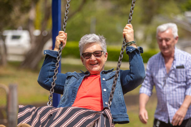 istock Active Senior Couple Playing on a Swing in the Park 1280430284