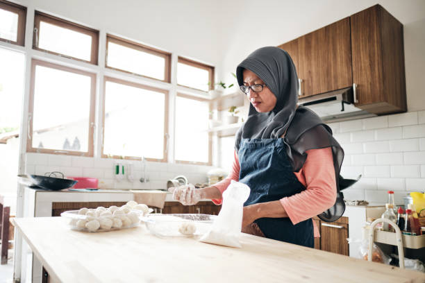 istock Senior woman making meal at domestic kitchen 1280446936