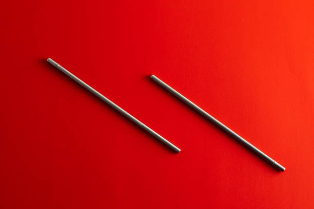 istock Reusable steel drinking straw in metallic color on red background 1280447025