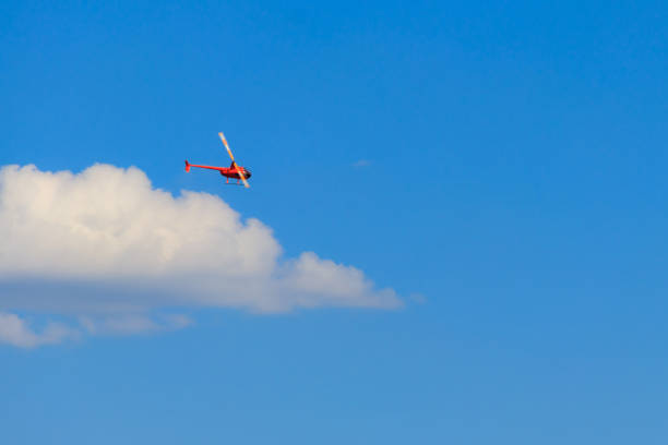 istock Flying orange helicopter in blue sky 1280449682