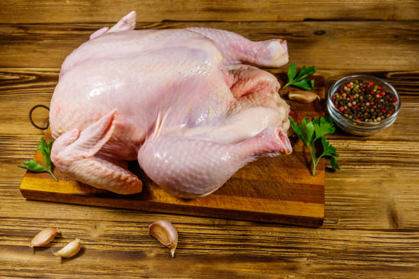 istock Raw whole chicken with spices on a wooden table 1280450432