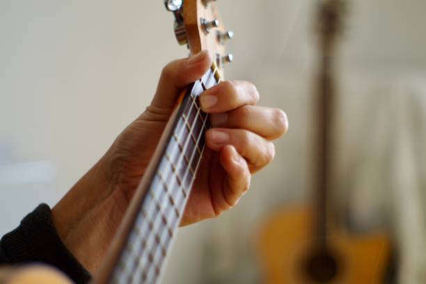 istock Close up of hands playing the ukulele 1280451220