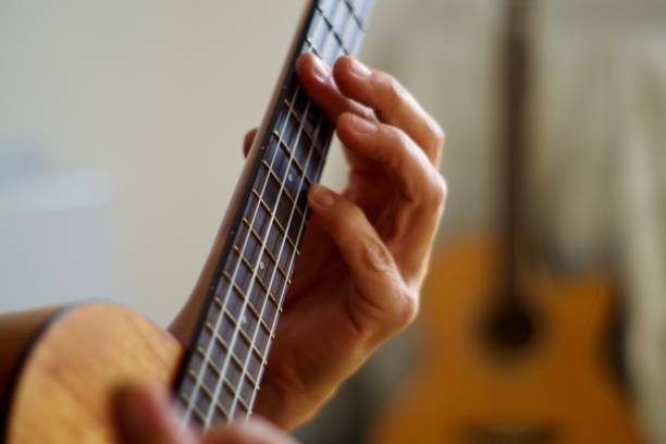 istock Close up of hands playing the ukulele 1280451225