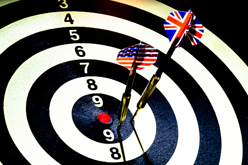 Dart with British and American USA flag board with darts in aim, with selective focus and high contrast