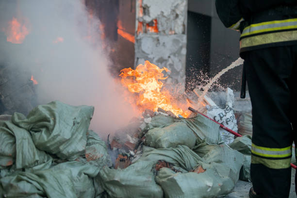 Firemen using extinguisher and water from hose for fire fighting in firefight training. Firefighter wearing fire suit for protect and safety under danger case.This team is under civil service system.