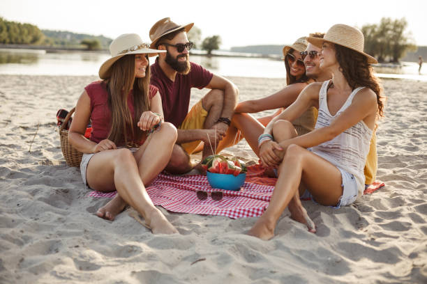 istock Cheerful friends having a relaxing picnic at the beach 1280459311