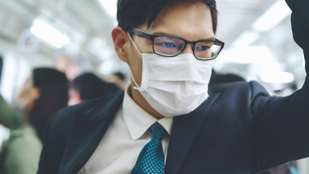 istock Young man wearing face mask travels on crowded subway train 1280460895