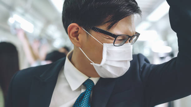 istock Young man wearing face mask travels on crowded subway train 1280461057