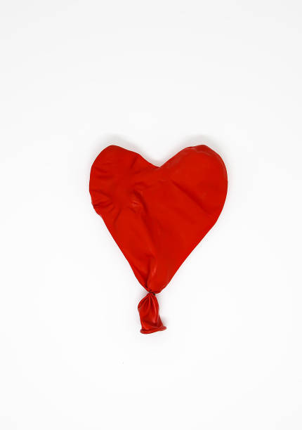 istock Red heart deflated balloon on white background. 1280462053