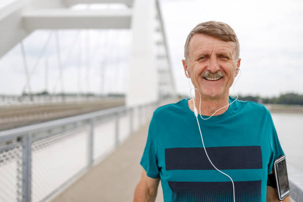 istock Smiling mature man with in ear headphones 1280462304