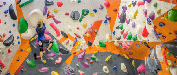 istock Woman climbing colourful wall 1280463286