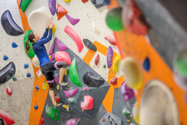 istock Woman climbing colourful wall 1280464185