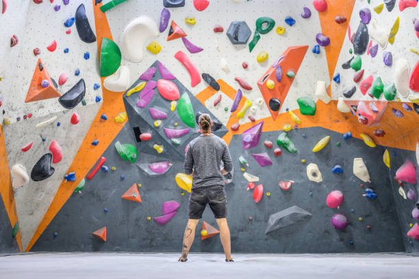 istock Man standing in indoor climbing gym 1280464339