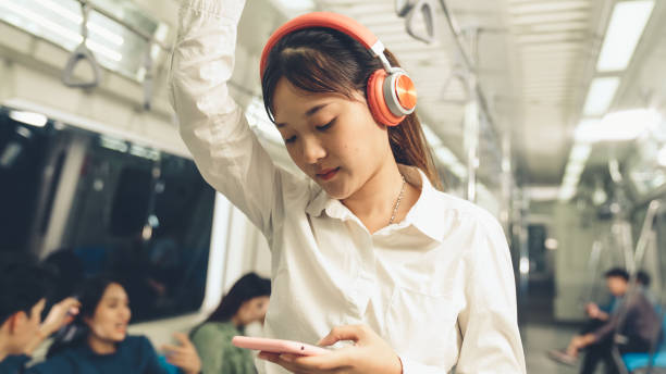 istock Young woman using mobile phone on public train 1280466216