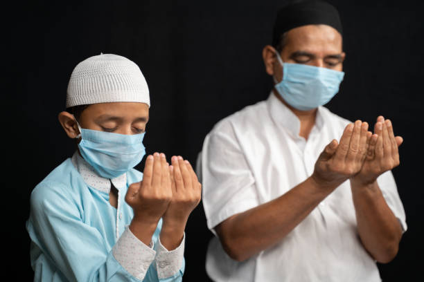 무슬림 아버지와 아들이 기도하거나 살라 오 코로나 바이러스 또는 covid-19앉아서 보호 수행 의료 마스크에 아들. - islam india mosque praying 뉴스 사진 이미지