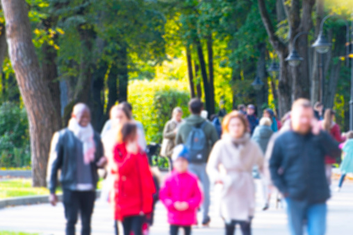 Moscow, Defocused blurred picture with people walking in city park