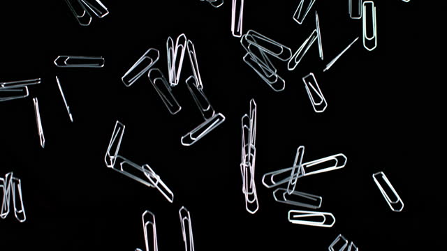 SLO MO LD Paper clips falling down