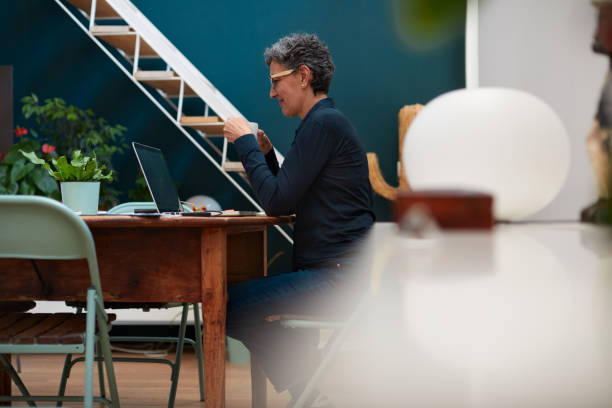 istock One woman drinking coffee and working late at home. 1280477508