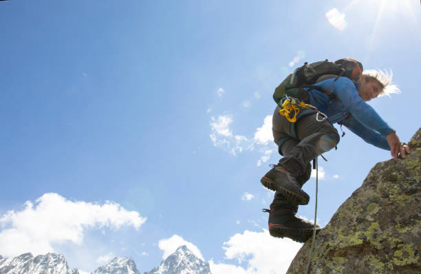 istock Mountaineer climbs up sunny mountain ridge 1280478915