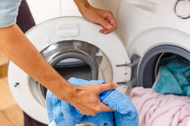istock Man loading cloths to washing machine. View from inside the washing machine. 1280479145