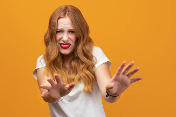 istock Pretty girl doing disgust face because aversion reaction with hands raised. Studio shot, yellow background 1280482597
