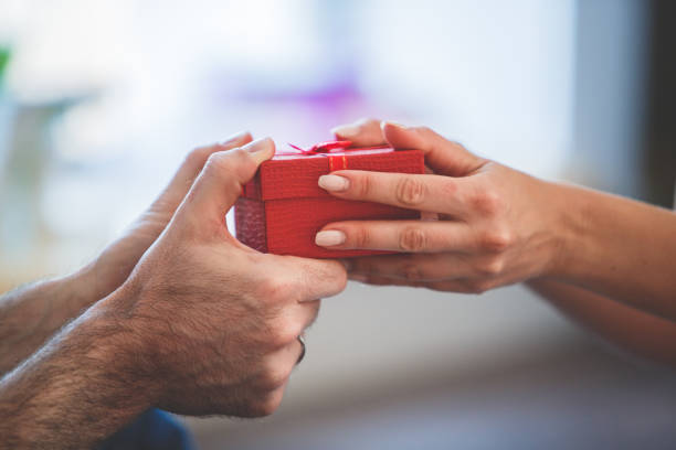istock Cut out of couple holding a gift 1280484982