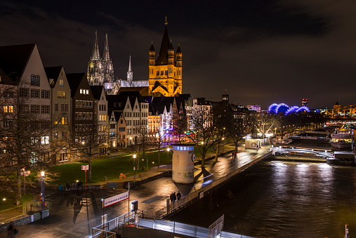 Cologne, Germany - February 17th 2020: Night-time view of the Rhine river with Great St. Martin Church and Cologne Cathedral in the city of Cologne, Germany.
