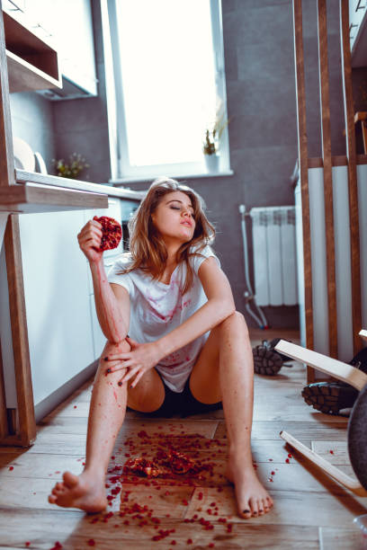 Female Beauty Squeezing Pomegranate And Spreading It All Over Kitchen