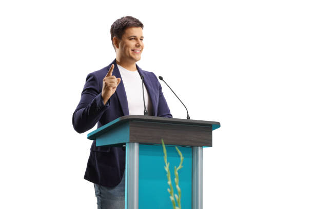 istock Man speaker with a hands free microphone on a pedestal gesturing with finge 1280490567
