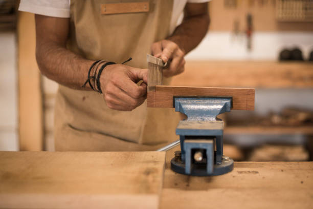 istock Close up of a young man working as carpenter in small carpentry workshop. 1280491378