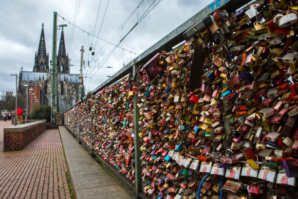 Cologne, Germany - February 20th 2020: Love Locks on the famous Hohenzollern Bridge in the city of Cologne, Germany. Cologne Cathedral is visible in the background.