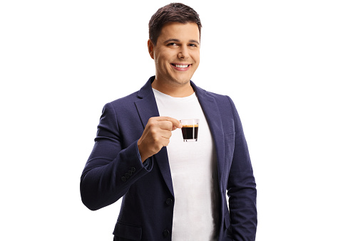 Smiling young man holding an espresso cup isolated on white background