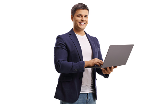 Young man with a laptop computer smiling at the camera isolated on white background