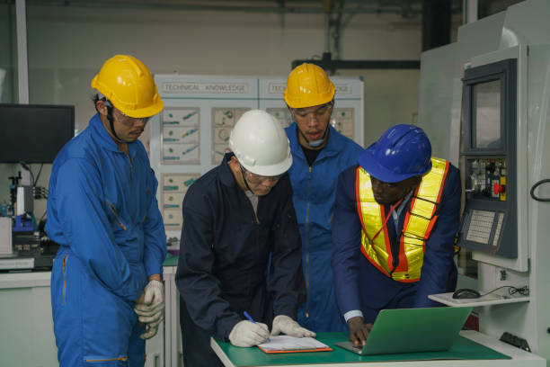 istock factory technician, foreman and workers in technical discussion of production process in machine control workshop of CNC metal work factory 1280492981