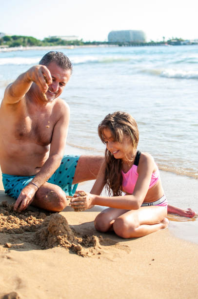 istock Happy father and her daughter playing to beach 1280500696