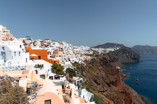 Santorini island, Greece. Oia town with traditional white houses and churches with blue domes over the Caldera, Aegean sea.