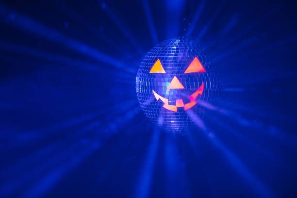 istock Halloween party pumpkin disco ball, jack-o-lantern with shiny rays in smoke 1280501280